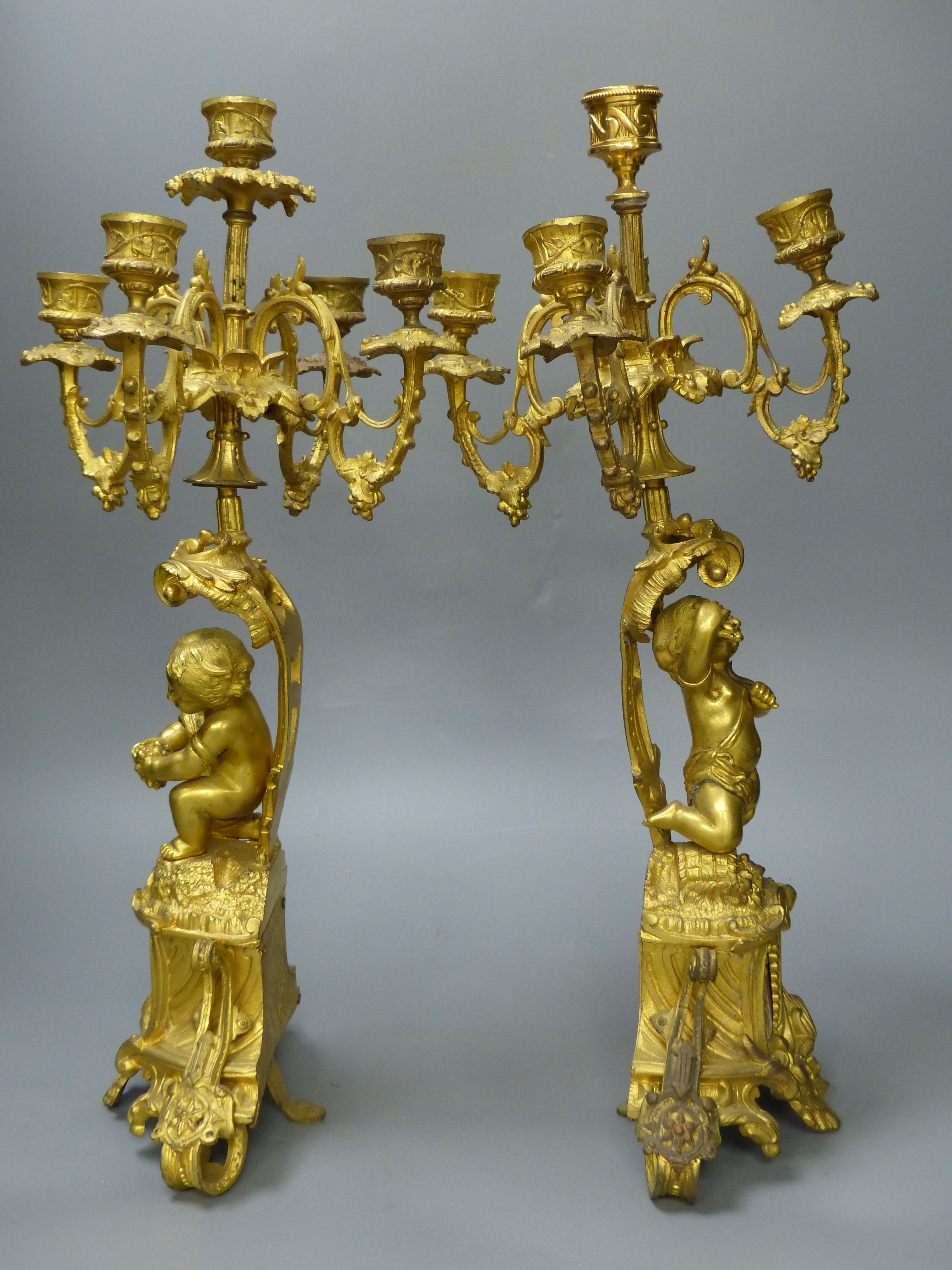 A pair of 19th century French ormolu cherub candelabra, with porcelain plaques to base, height 47.5cm